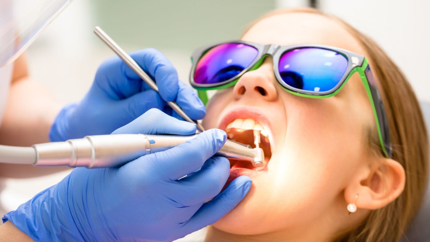 Shows an older child getting a dental cleaning from the pediatric dentist in Northern New Jersey.