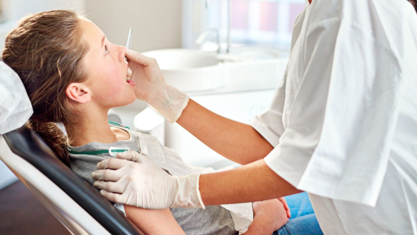 A child is at a dentist office, getting treatment for a cavity.