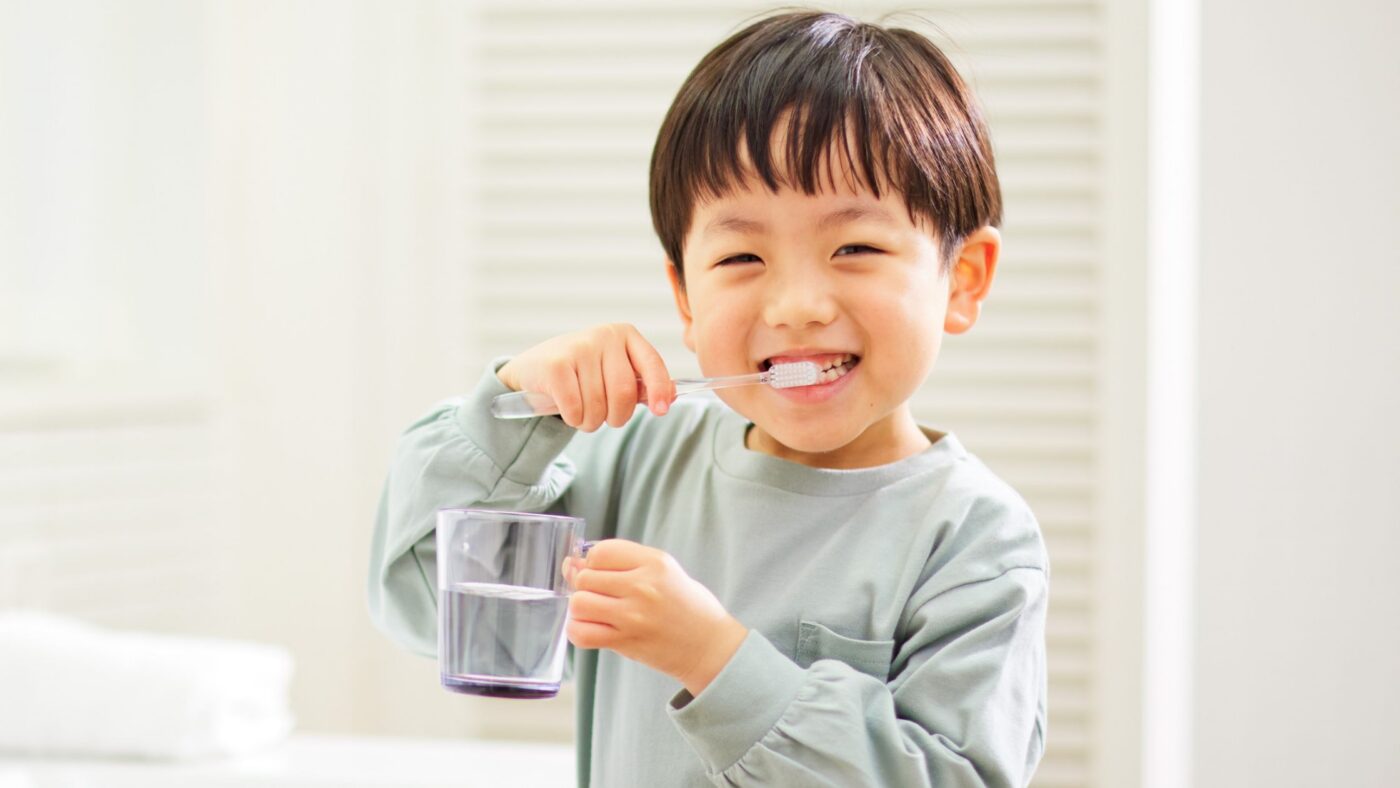 young child brushing teeth