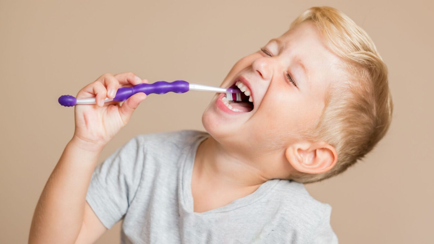 Best toothpaste for kids: young child brushing teeth with a toothbrush.