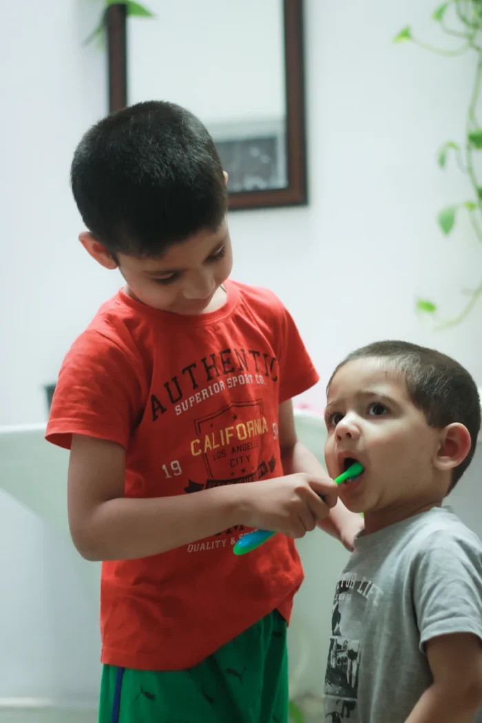 Two brothers brushing their teeth at a bathroom sink